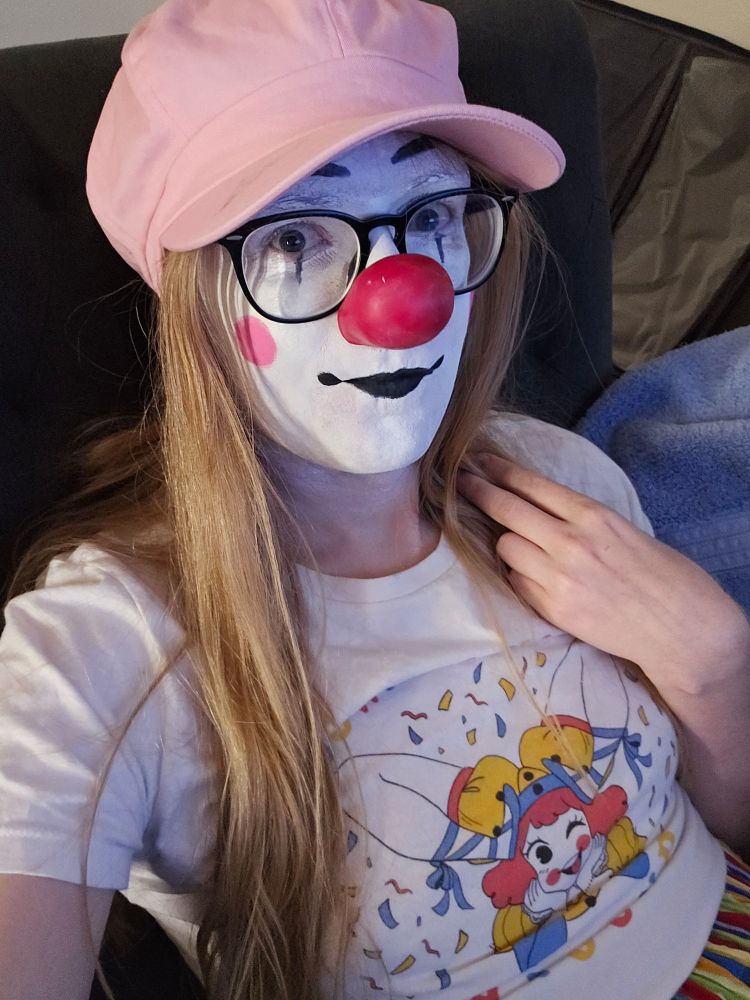 Clown girl with big pink cap taking a selfie.