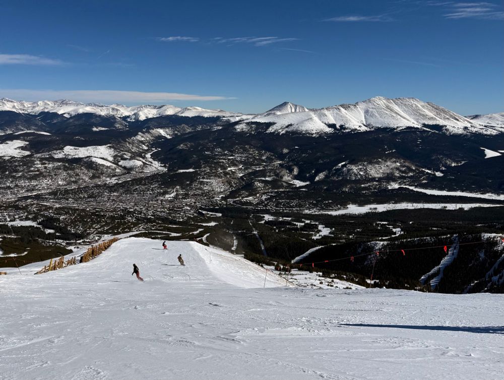 a view of mountains and people snowboarding