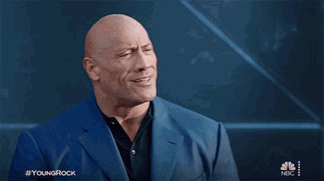 Dwayne Johnson, nickend und die rechte flache Hand auf die linke Brustseite klopfend.