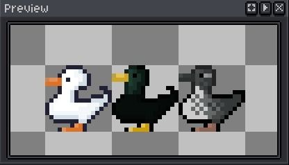 Três patos lado a lado, da esquerda para direita, Pato Branco com pompom na cabeça, Pato Preto com verde escuro e Pato cinzento com partes brancas