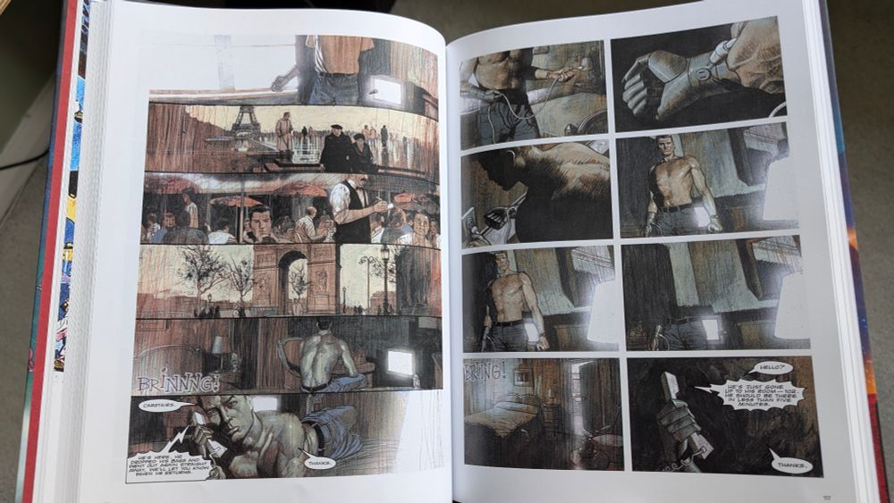 An open book showing two almost-wordless comics pages, drawn by Sean Phillips, of The Steel Claw from 1992.