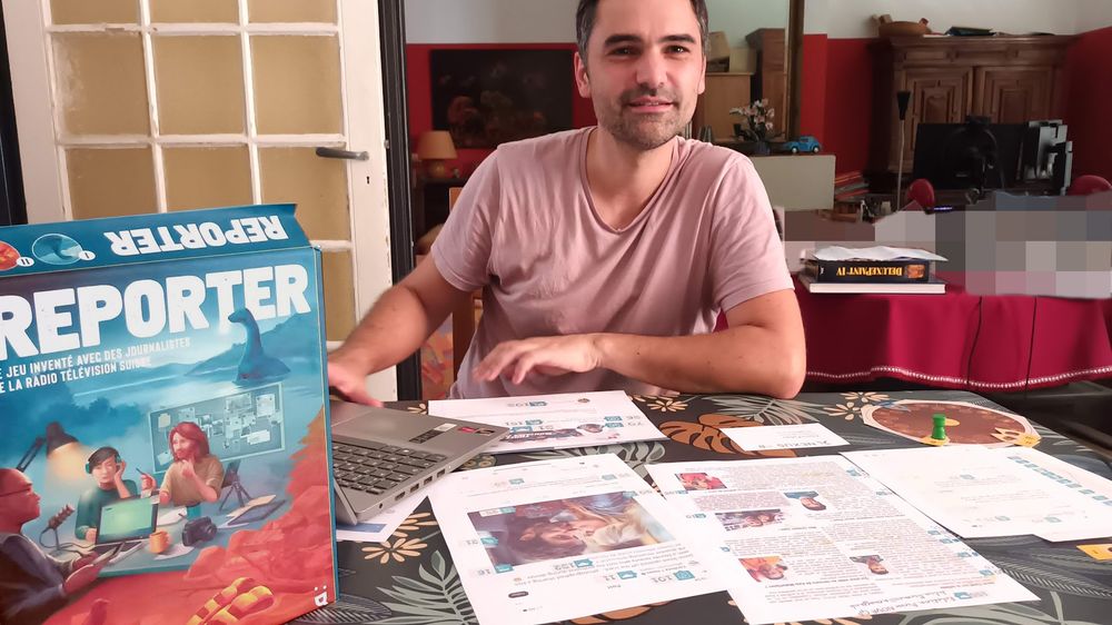 Jeremie en plein test, avec la roue de temps et des évènements, et deux indices imprimés. Il regarde le livret PDF sur son ordi, le vrai jeu a des carnets distribués aux joueurs. Boite proto du 1er Reporter à gauche.