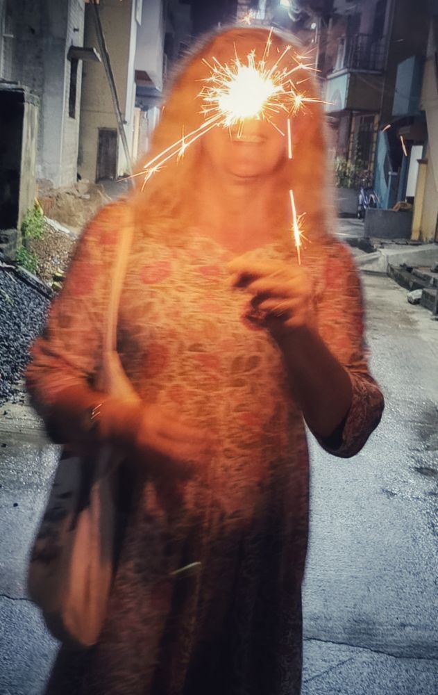 Holding a sparkler at Halloween. Tiruvannamalai, Tamil Nadu, India.