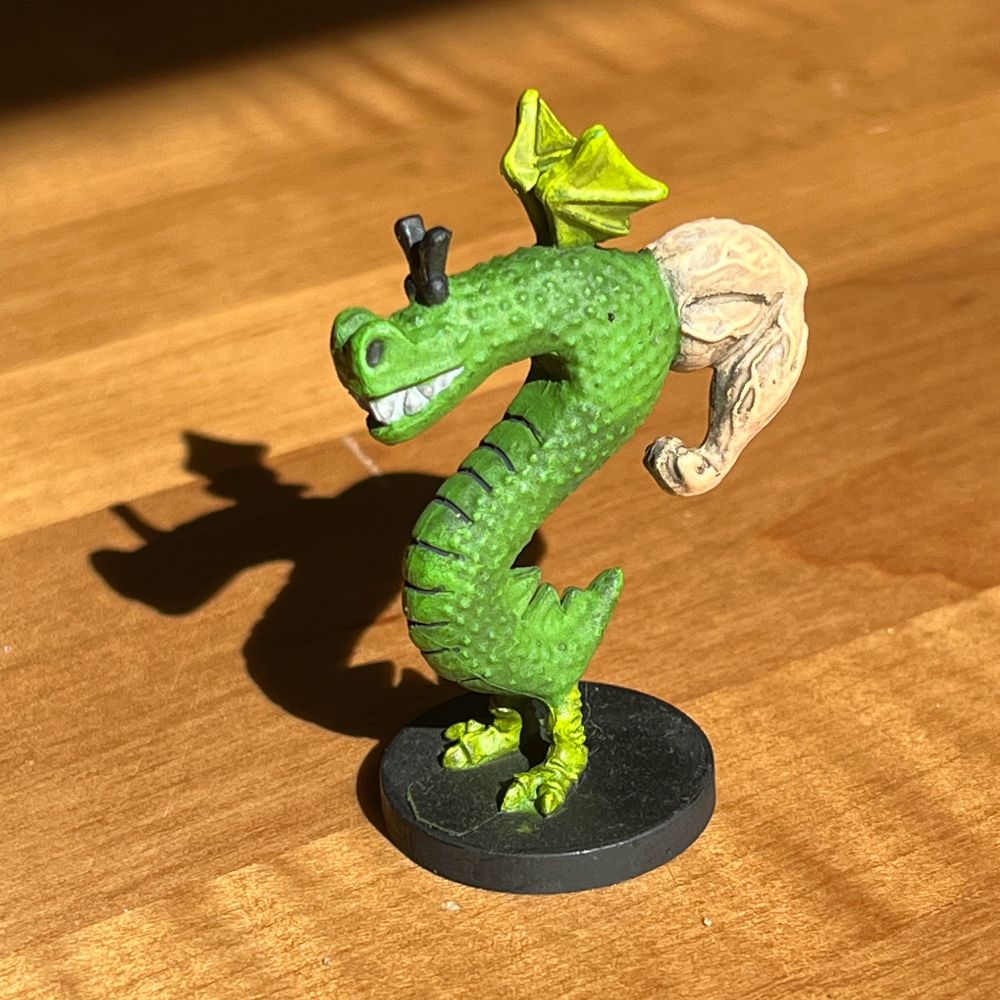 Trogdor figure from the board game. Trogdor is an S-shaped wingaling dragon with a big beefy arms and consummate Vs.