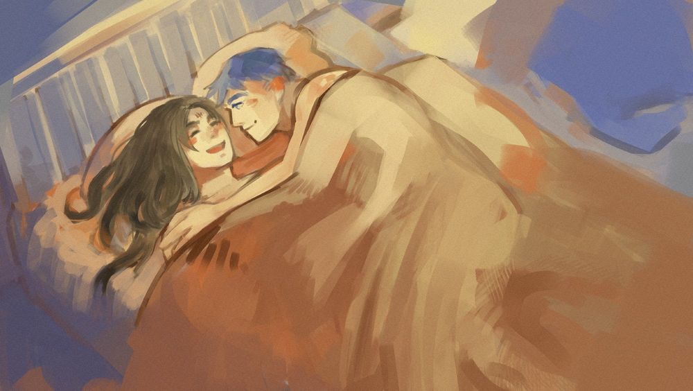 Ike and soren in a bed they are cuddling and smiling.