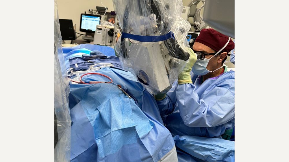 man in surgical scrubs looking at an imaging machine at USC Otolaryngology at the human inner ear