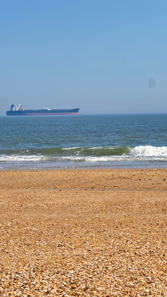 Oil tanker passing offshore of a rocky beach in Delaware 