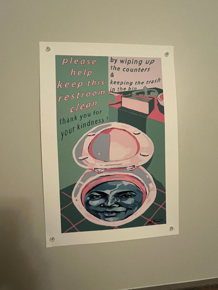 A bathroom sign reminding people to clean up after themselves. Features a watercolor painting of a woman’s face in the toilet.