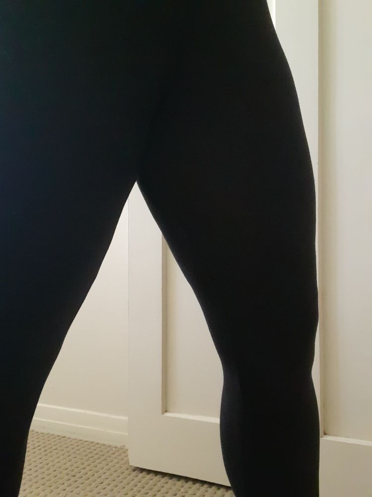 The black leggings shown in the previous photos now worn by the person fixing them. The inner seam has been fixed and there is no visible white stitching. 