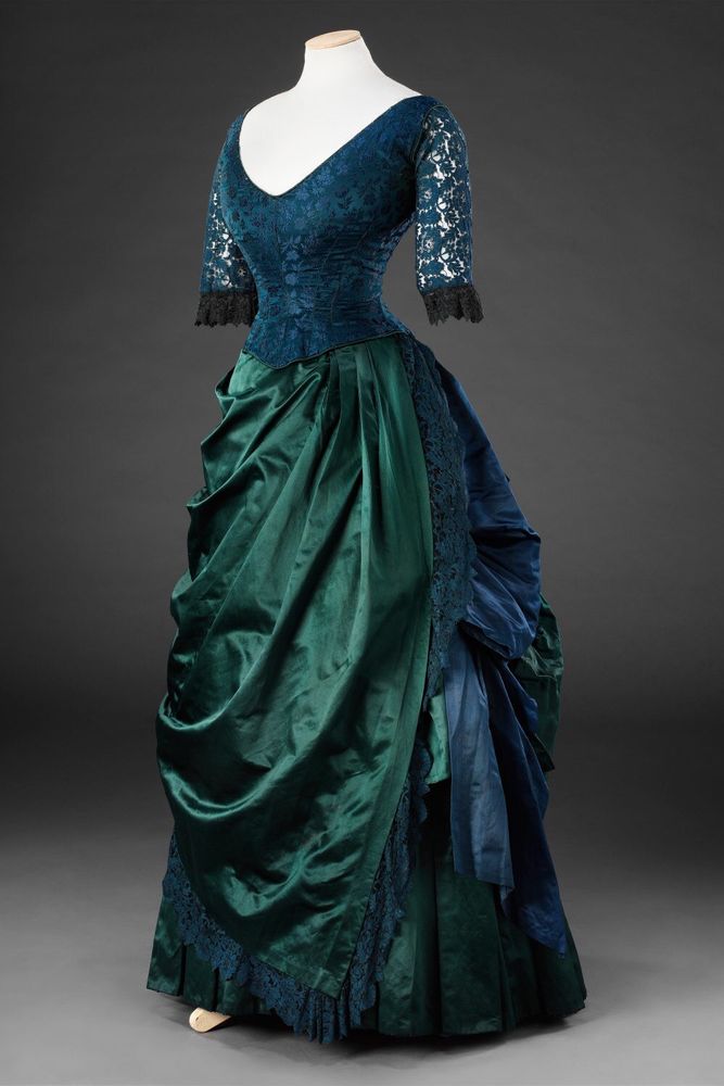 Front/side view of blue/green two-piece evening dress, bustle back, c1886-7, silk & lace, trimmed with lace, JB