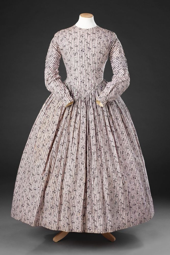 Front view of mid 1840s one piece day dress, cotton calicos printed in purple a popular choice for practical day dresses, JB