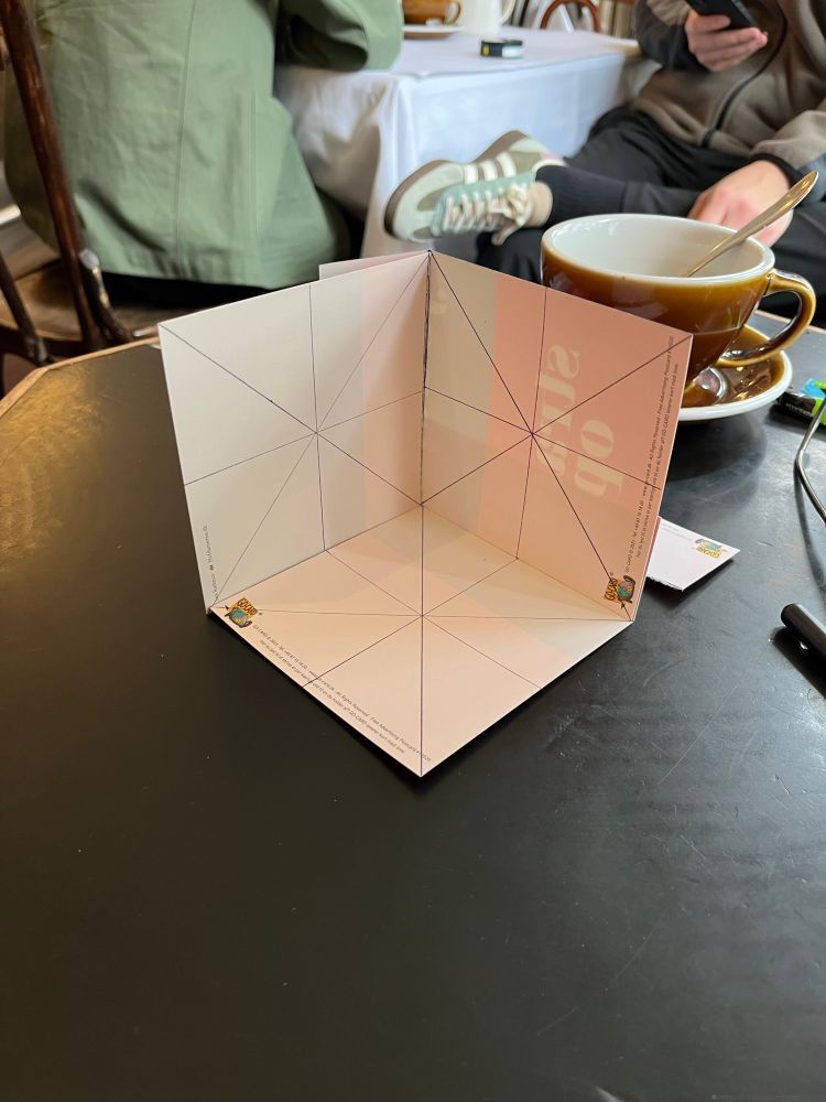 Three squares each divided into a Union Jack pattern and arranged such that they align to the three principal axis thus creating a 3 dimensional grid.