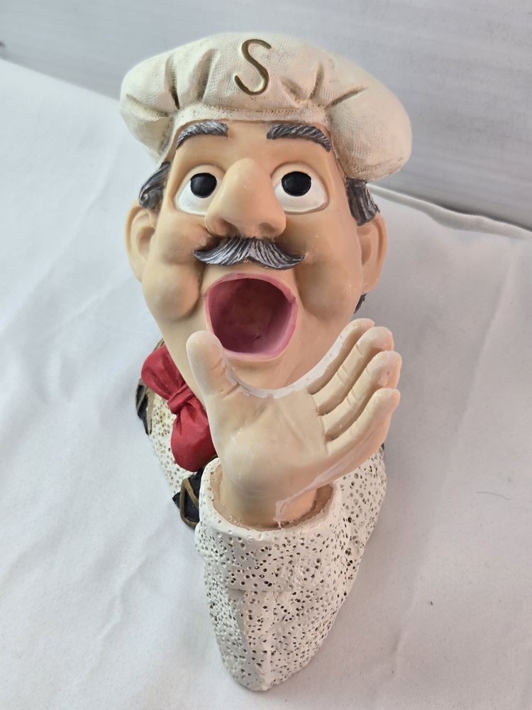a fat british pensioner chef cups his hand and opens his mouth ready to receive 
