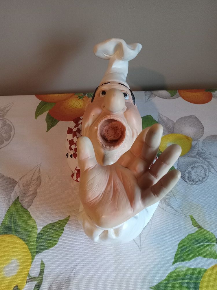 an italian chef cups his hand and opens his mouth ready to receive 