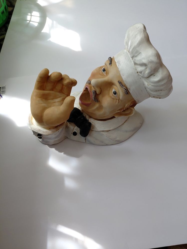 an italian chef with a cute little mustache cups his hand and opens his mouth ready to receive 