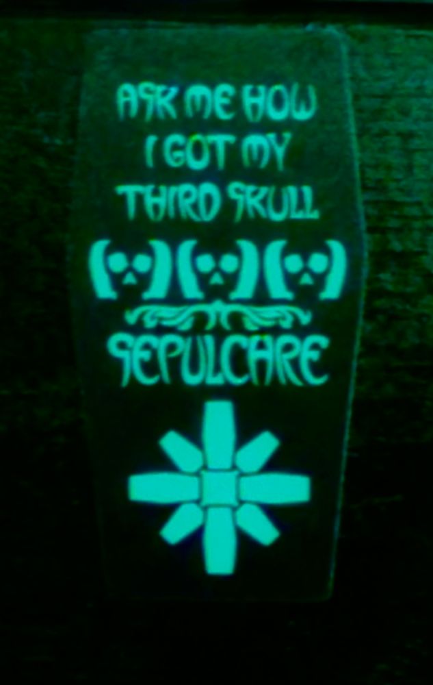 Glow in the dark sticker in the shape of a coffin that reads: Ask me how I got my third skull.
Followed by a row of cartoon skulls and the logo for the Sepulchre board game.