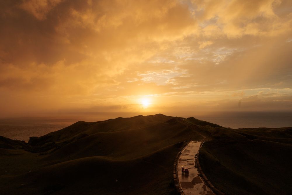 Sunset over rolling hills after rain