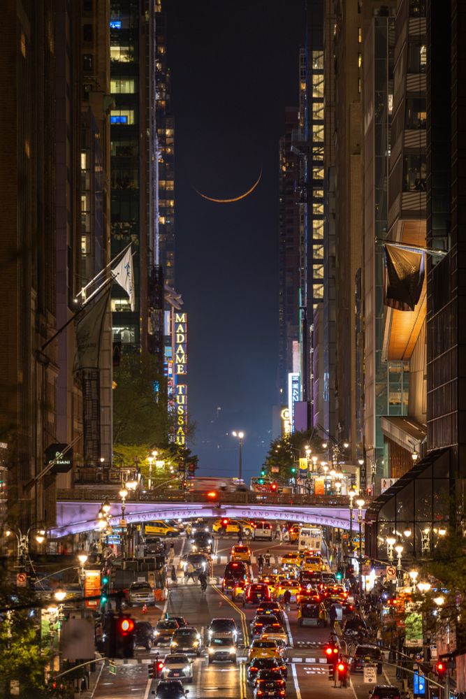 Thin crescent moon seen between the skyscrapers of 42nd st in Manhattan