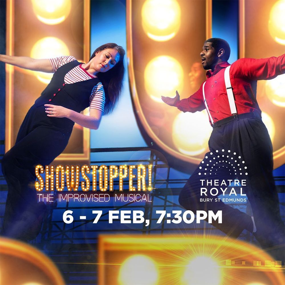 Lucy and Joshua infront of the Showstopper! sign, text says: 'Showstopper! The Improvised Musical. Theatre Royal Bury St Edmunds. 6-7 Feb, 7:30pm.