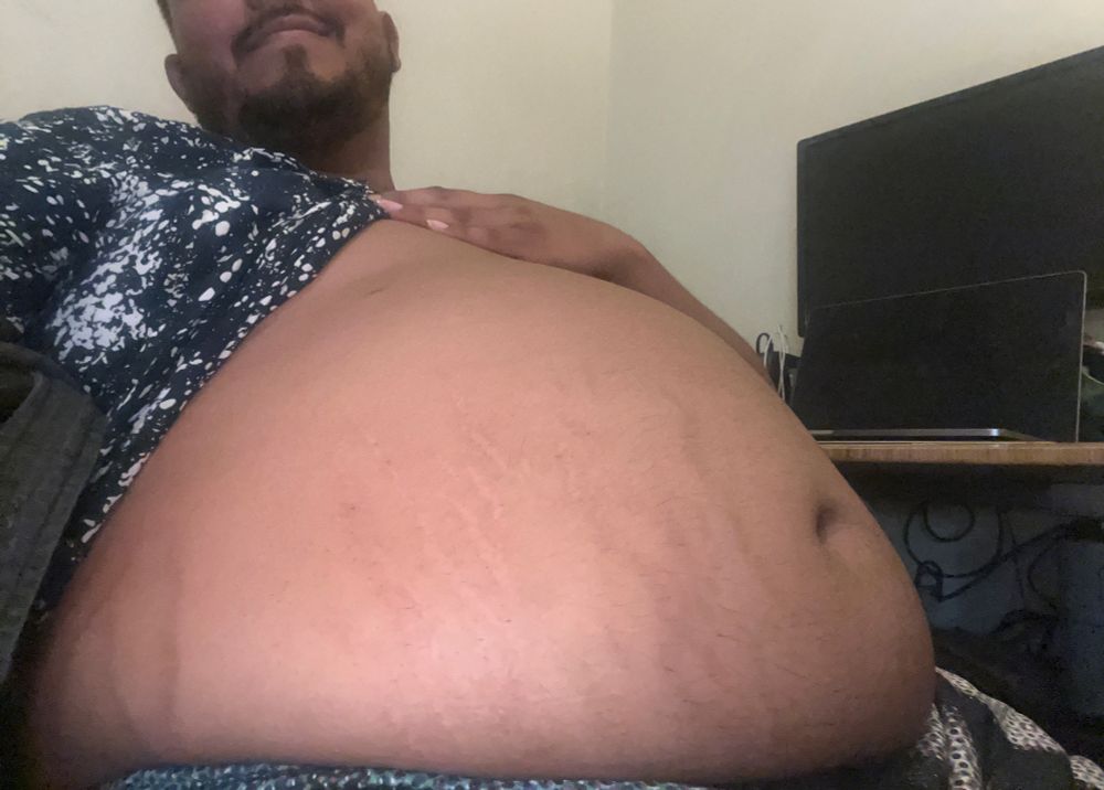 photo of me lifting up my blue and white shirt to reveal my big brown belly replete with stretch marks