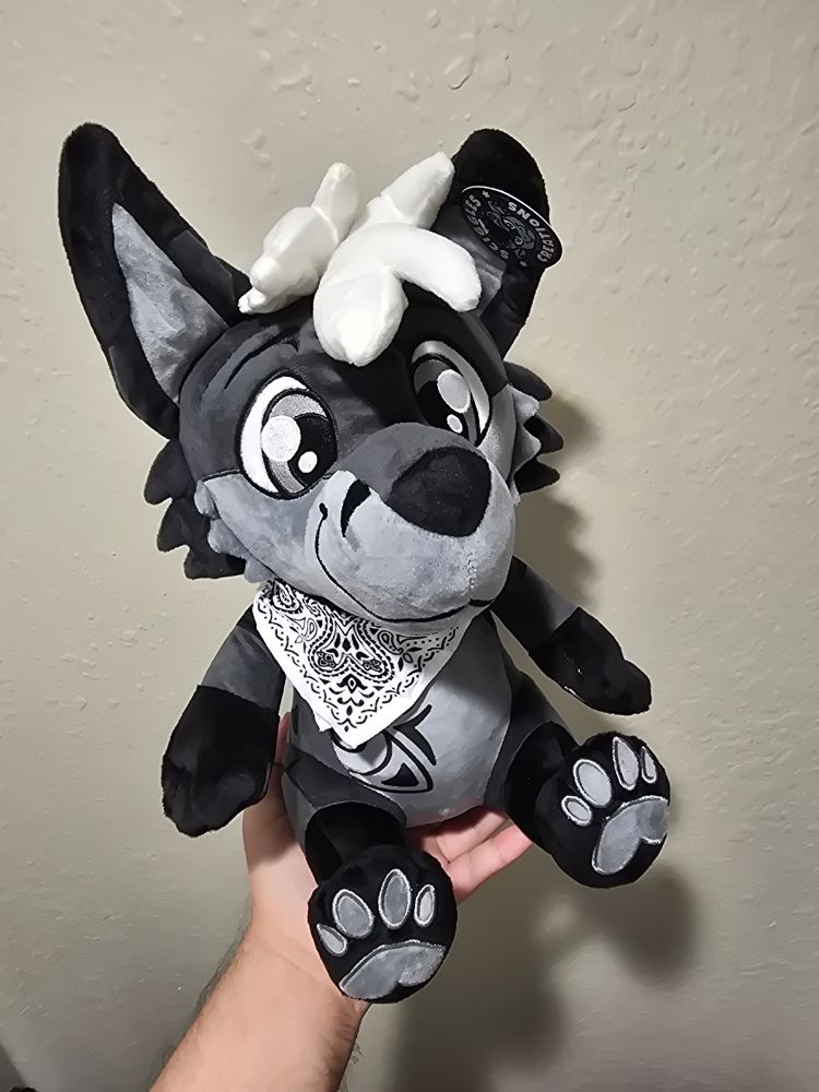 A picture of a plush of grey fox character Aydan