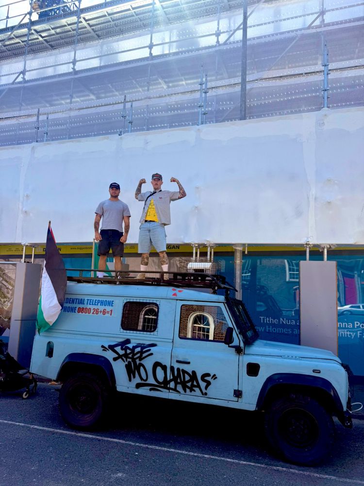 The Kneecap RUC landrovet, with Soft Play on top, a Palestine flag on the back, and "Free Mo Chara" graffiti on the side.