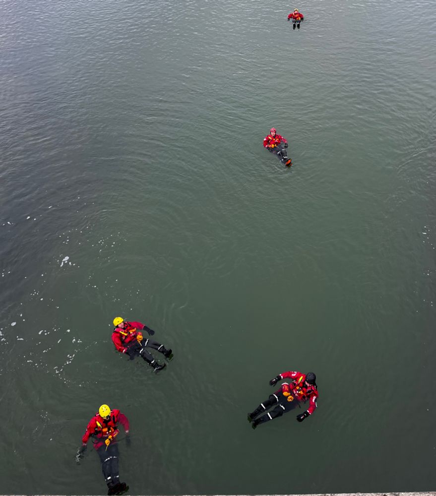 Adur River. 
Fire crews practising line rescue. Five firefighters in full gear, floating on their backs. Shot from high up looking down at the crew.