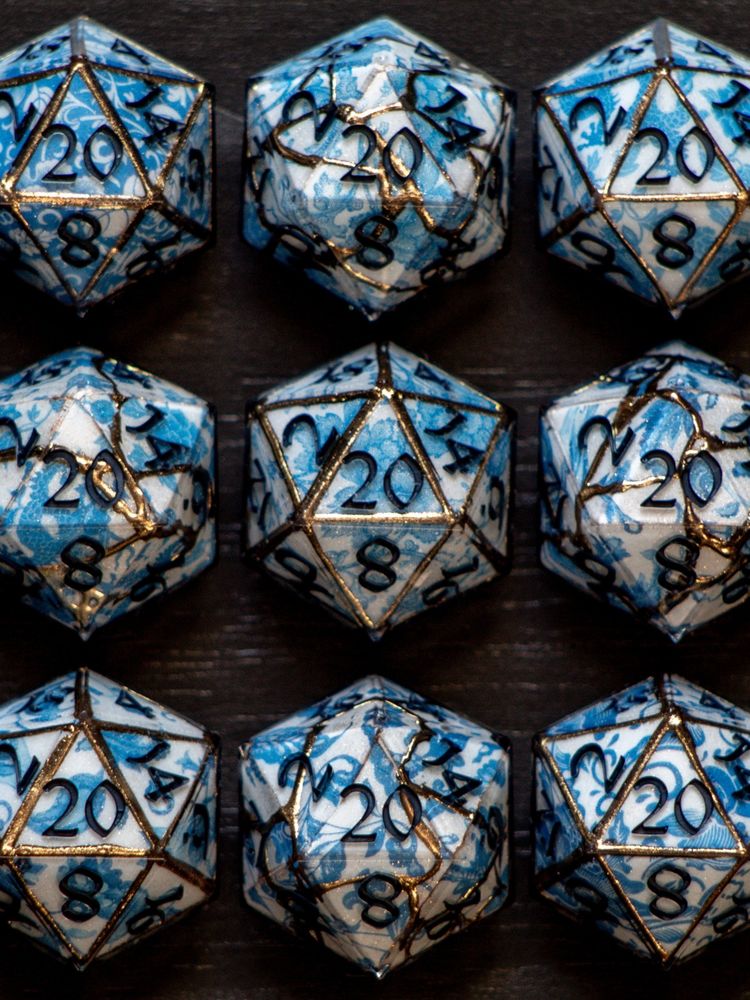 Handmade D20s painted to look like gilded porcelain. 