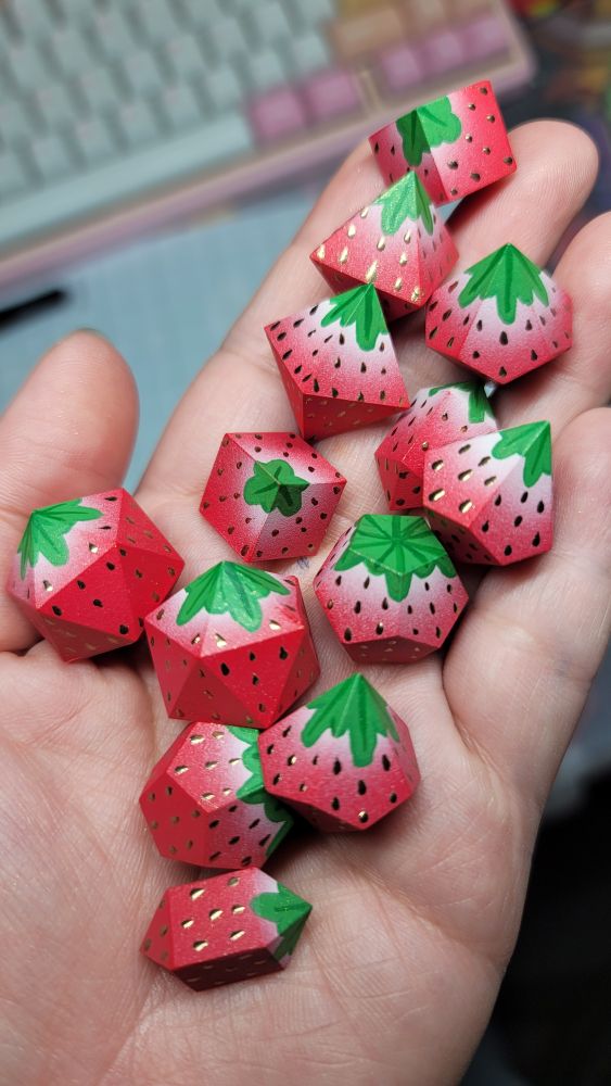 Handpainted polyhedral dice blanks painted to look like strawberries with gold chrome seeds.
