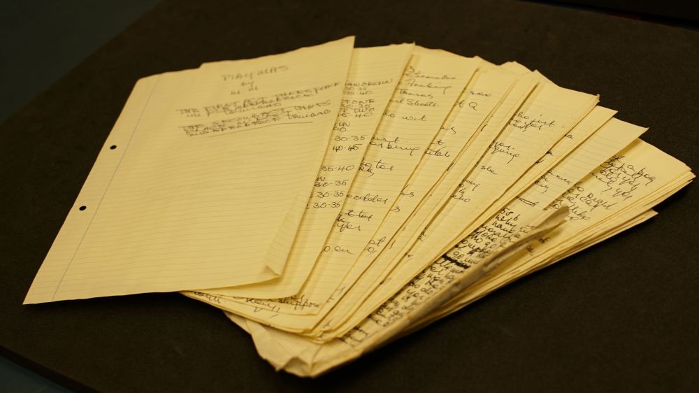 Archive of Mustapha Matura, showing a pile of handwritten scripts arranged in fan shape.
