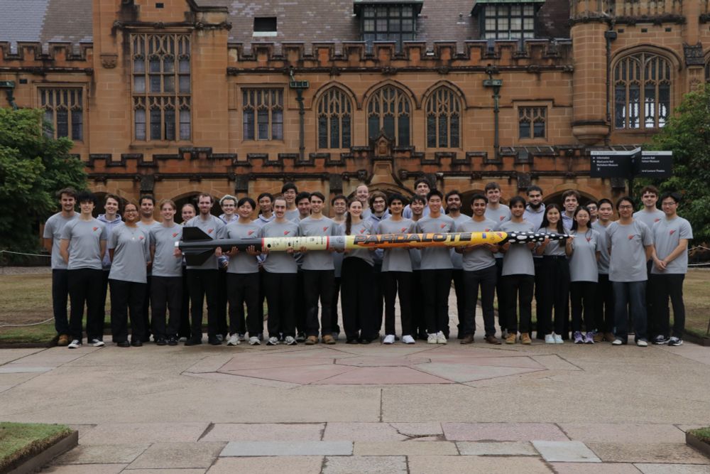 USYD Rocketry Team holding rocket in Quadrangle.