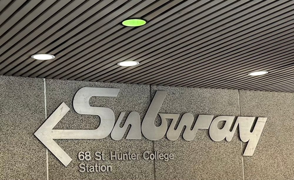 stulized subway station sign at 
68 st hunter college
