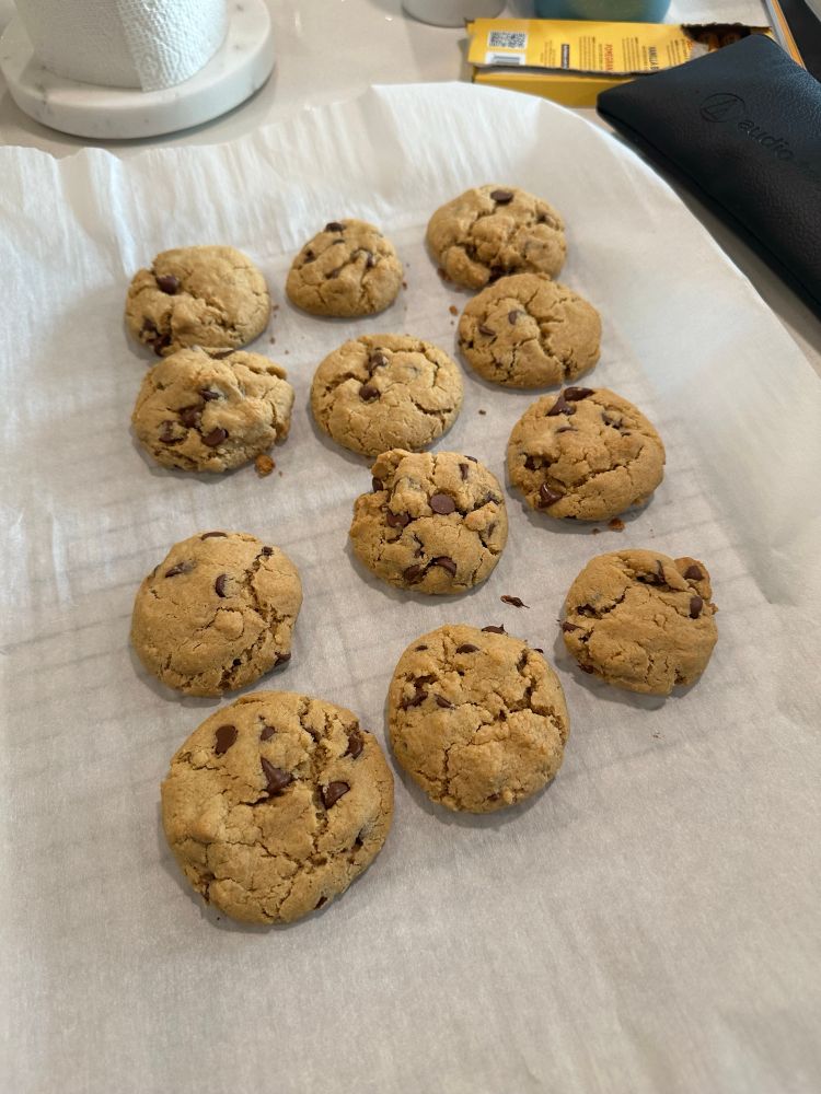 Peanut butter chocolate chip cookies on parchment paper to cool