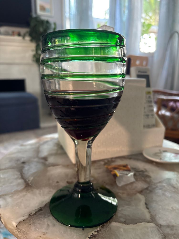 A glass of red wine in a green wine glass