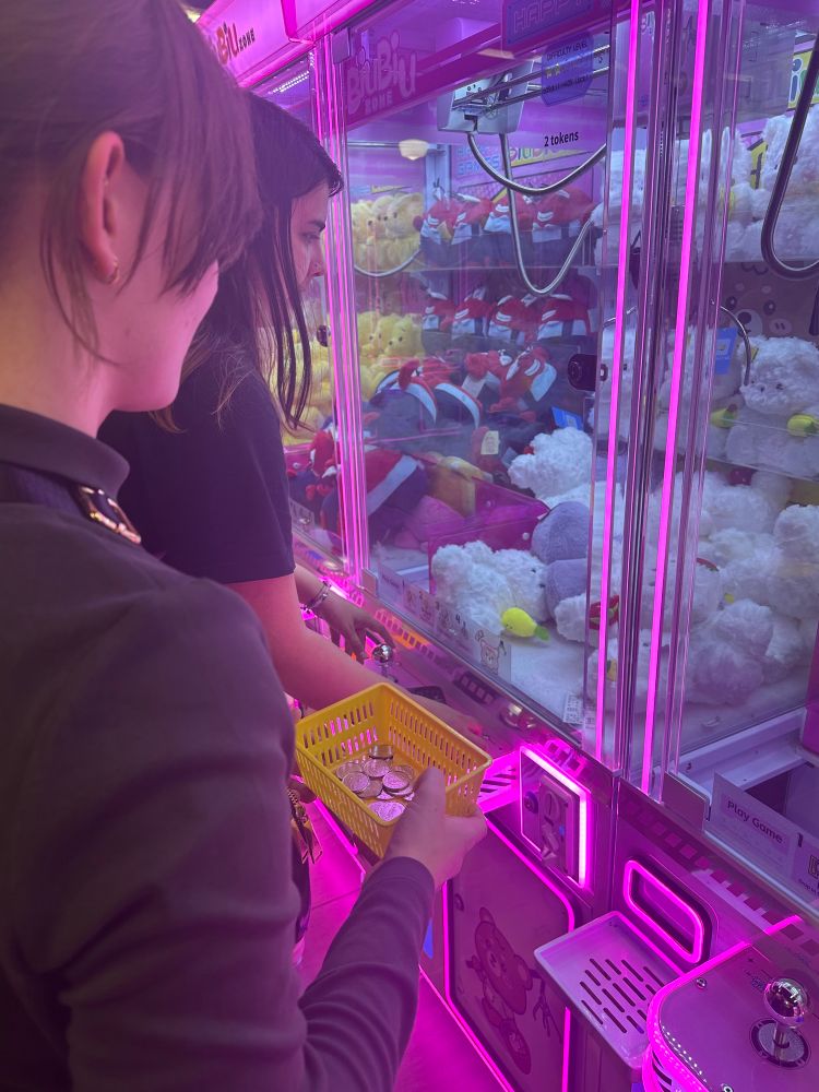 two of my bestest friends playing a claw machine, they won a white bear plushie holding a strawberry!! 