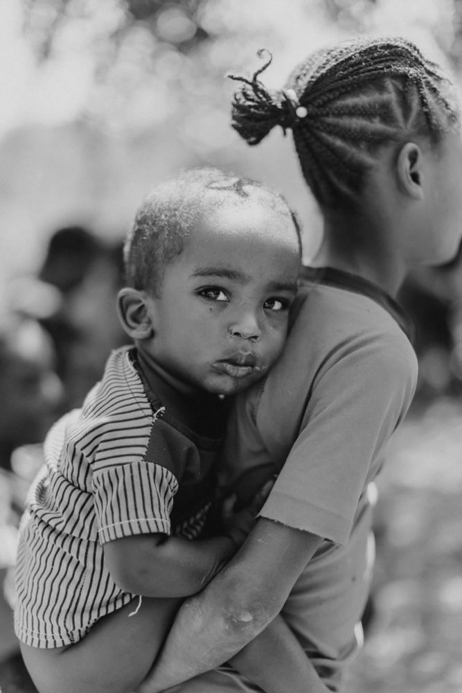 Small child on back of sibling - members of the community of Ferra Gossa, Ethiopia