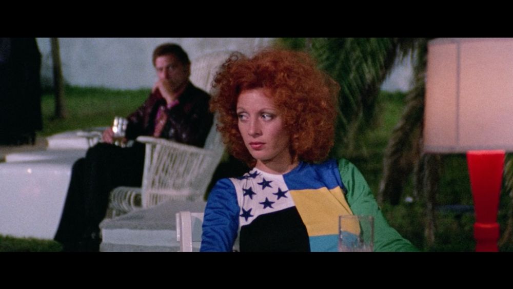 A redhead woman wearing an over-the-top party dress as an older man looks onward