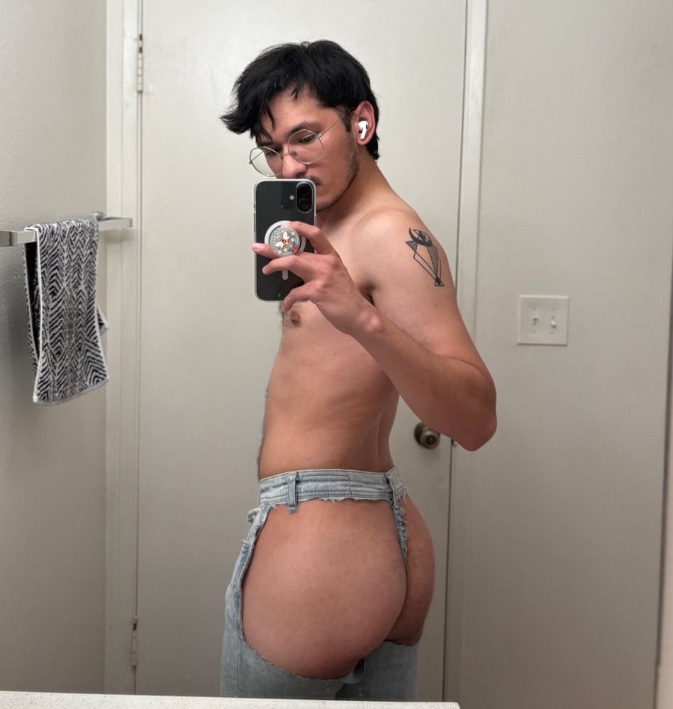 Justa showing off exposed cheeks through cut jeans
