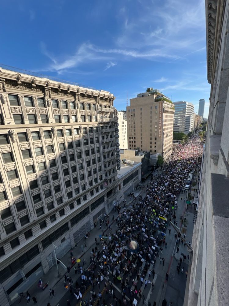 Hill Street in downtown Los Angeles, looking south from 4th. The street is is filled with marching protesters, for blocks and blocks and blocks.