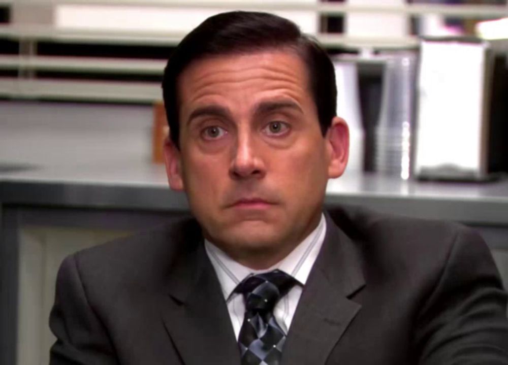 a man in a suit and tie making a face