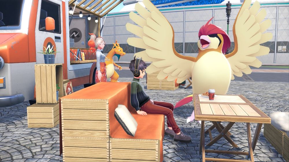 Me and my pidgeotto sitting at a table. There’s a food truck behind us with a charizard and a waitress.