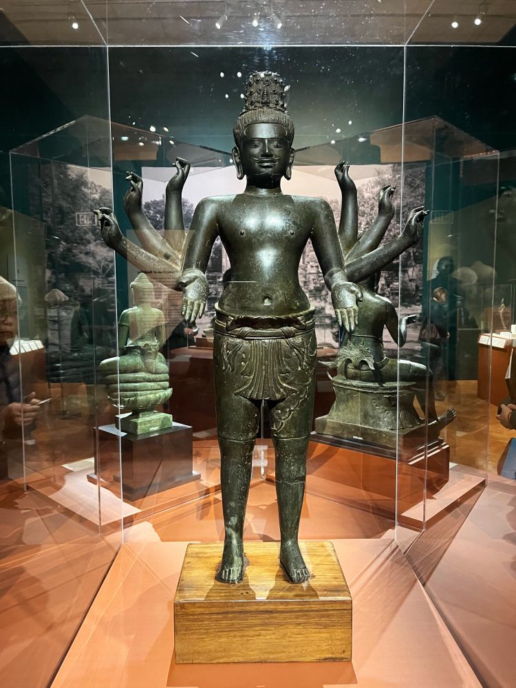 Cambodia, Kampong Chhnang province,
Kampong Tralach district, Wat Ampil Tuk Buddhist monastery

Bodhisattva Maitreya, Angkorian period, beginning of the 10th century

High-tin bronze, silver, possibly glass or stone National Museum of Cambodia, Phnom Penh, contribution of the Royal Library 1926, Ga.2024

This sculpture depicts the bodhisattva Maitreya, identifiable here by the small stupa at the front of his stylized hair. Made in the early 10th century, this work attests to the existence of complex forms of Tantric:
Buddhism in Cambodia from the beginning of the Angkorian period. The two main hands symmetrically perform the gesture of charity. The other six hands likely held related attributes, but no assumptions can be made as to their nature.