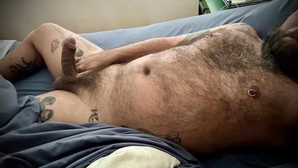 In bed, showing you my bushy uncut morning wood and hairy body. 