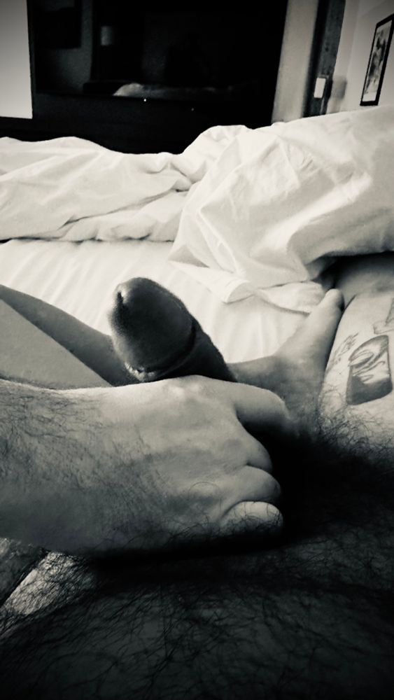 A hand stroking my bushy uncut morning wood 