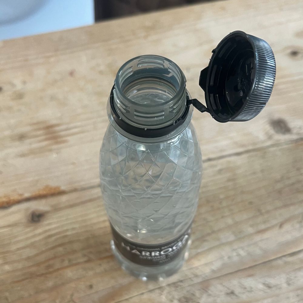 Wasser-PET-Flasche mit angehängter Verschlusskappe