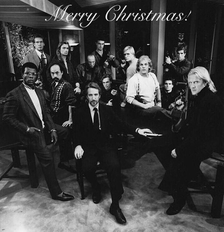 A black and white promo photo of the baddies from Die Hard, with the words “Merry Christmas!” at the top. They are scowling with delight. 