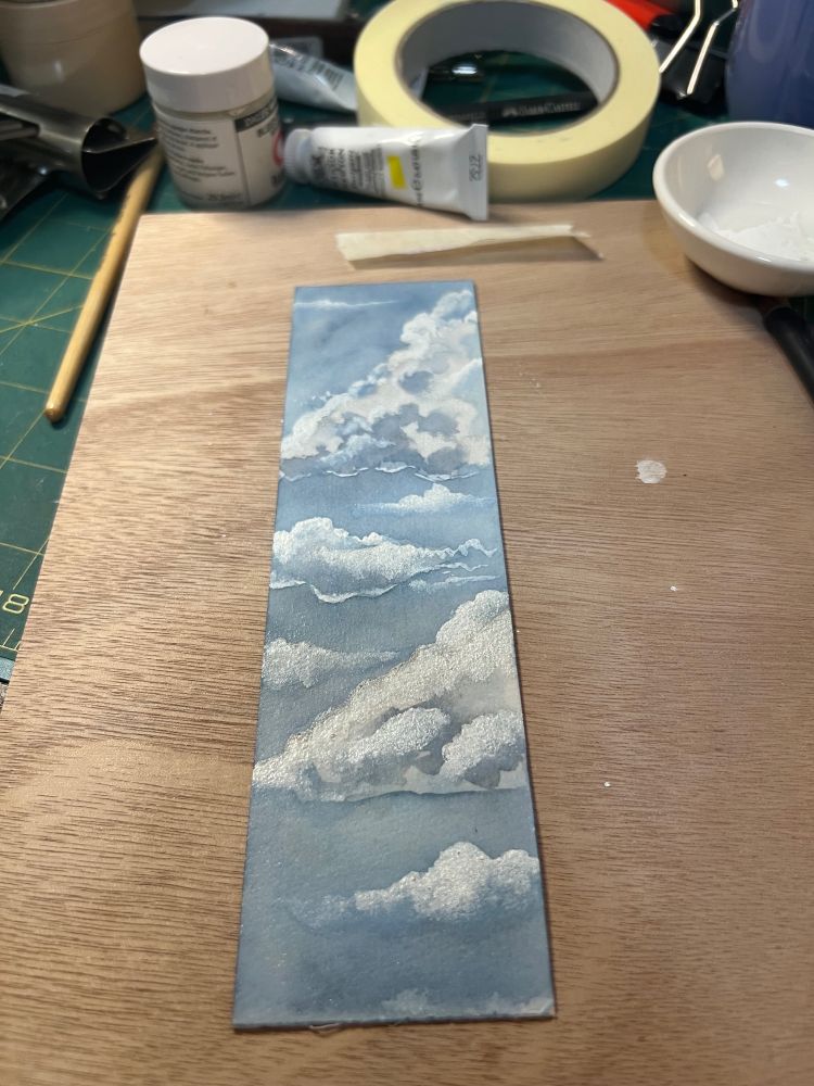 A bookmark with paintings of clouds