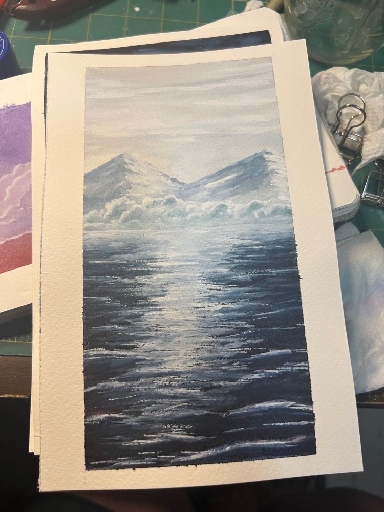 A watercolor of two mountains that look like boobs (kind of, unintentionally) and low laying clouds.