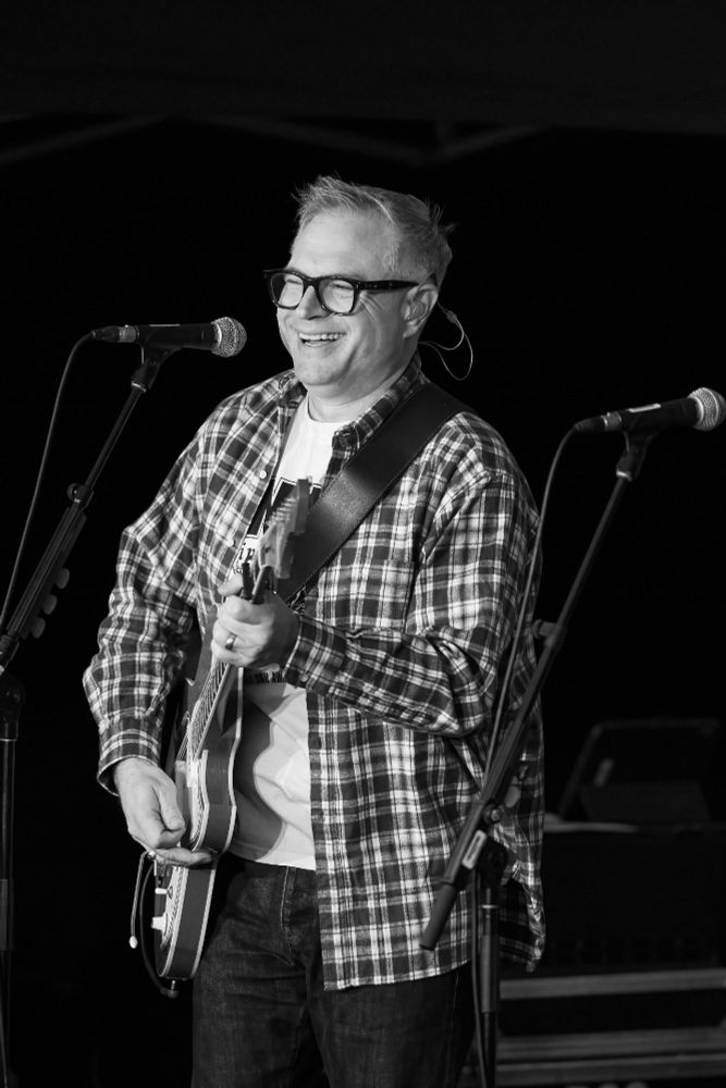A black and white photo of Steven Page performing. 