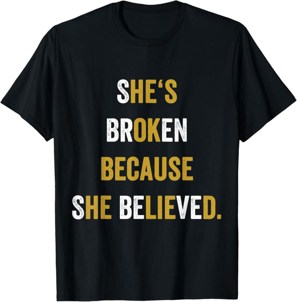T-shirt that says “she’s broken because she believed” with certain letters re-colored to add the hidden message “he’s ok because he lied”